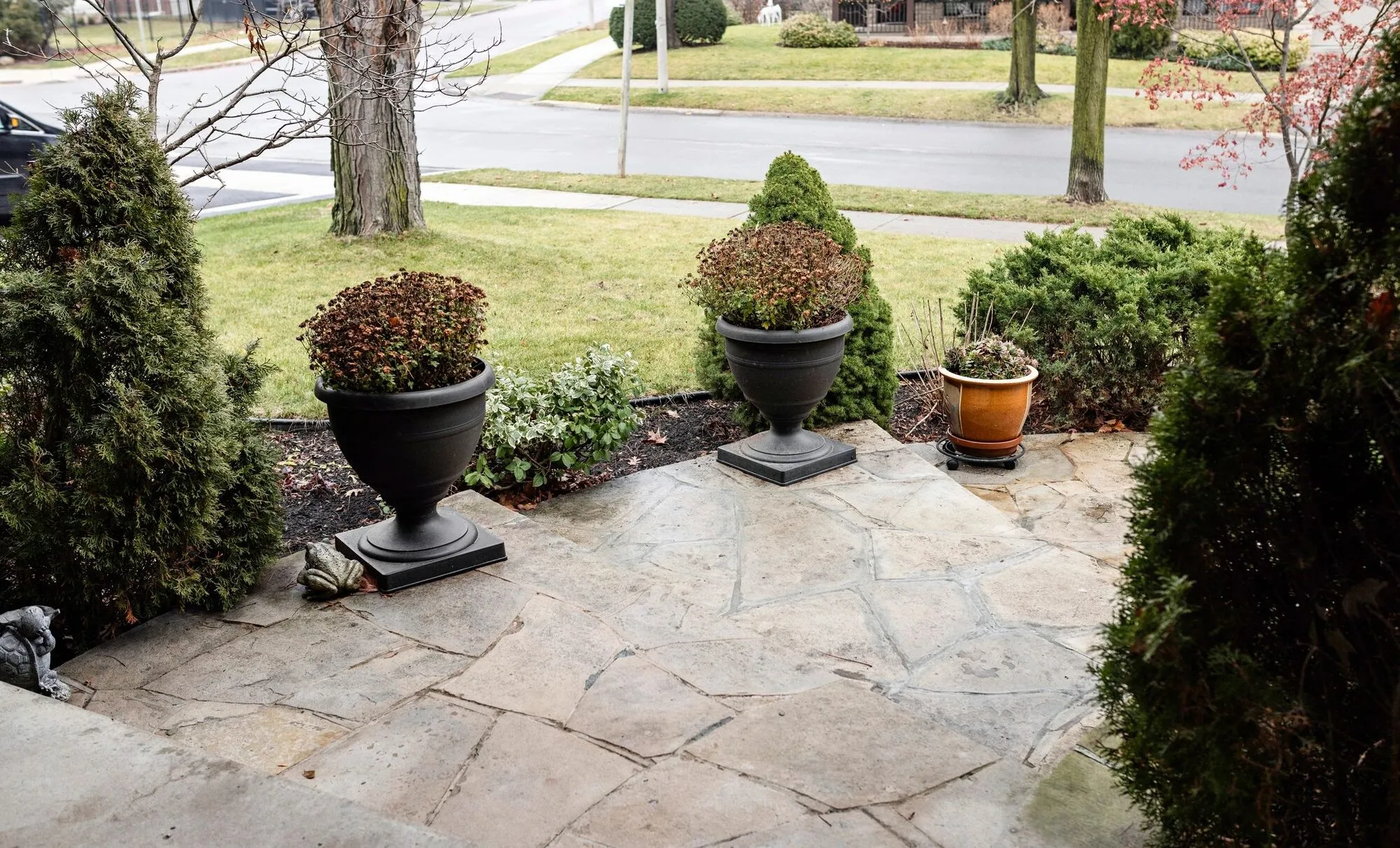 Natural flagstone patio with potted plants and shrubs