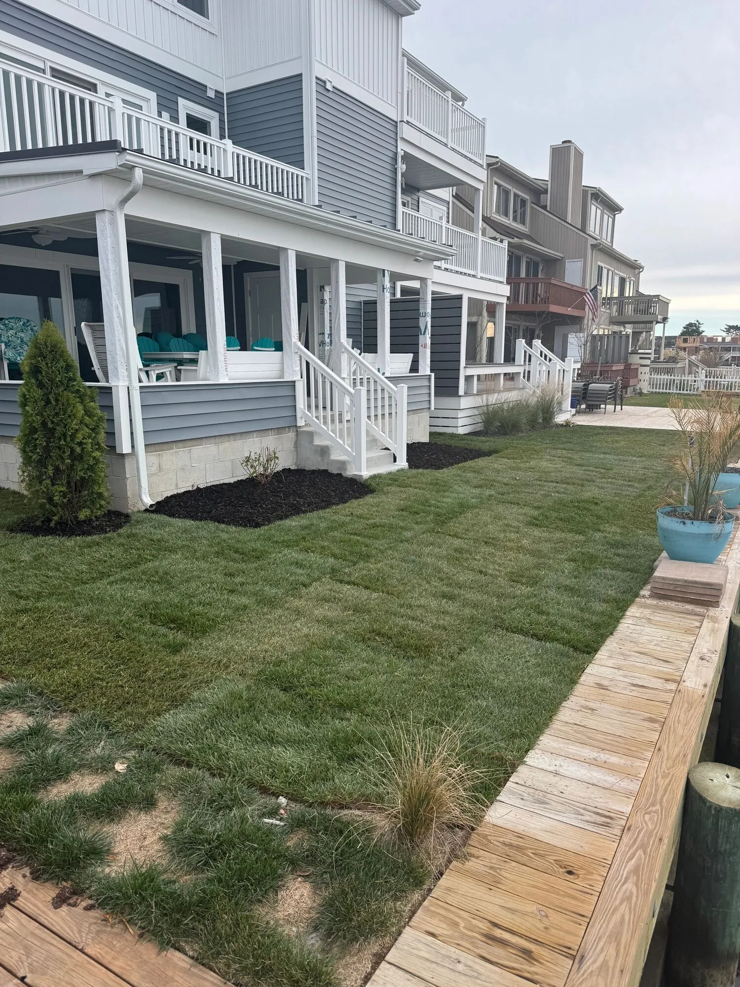 New lawn and mulched shrub beds in front of a waterfront home