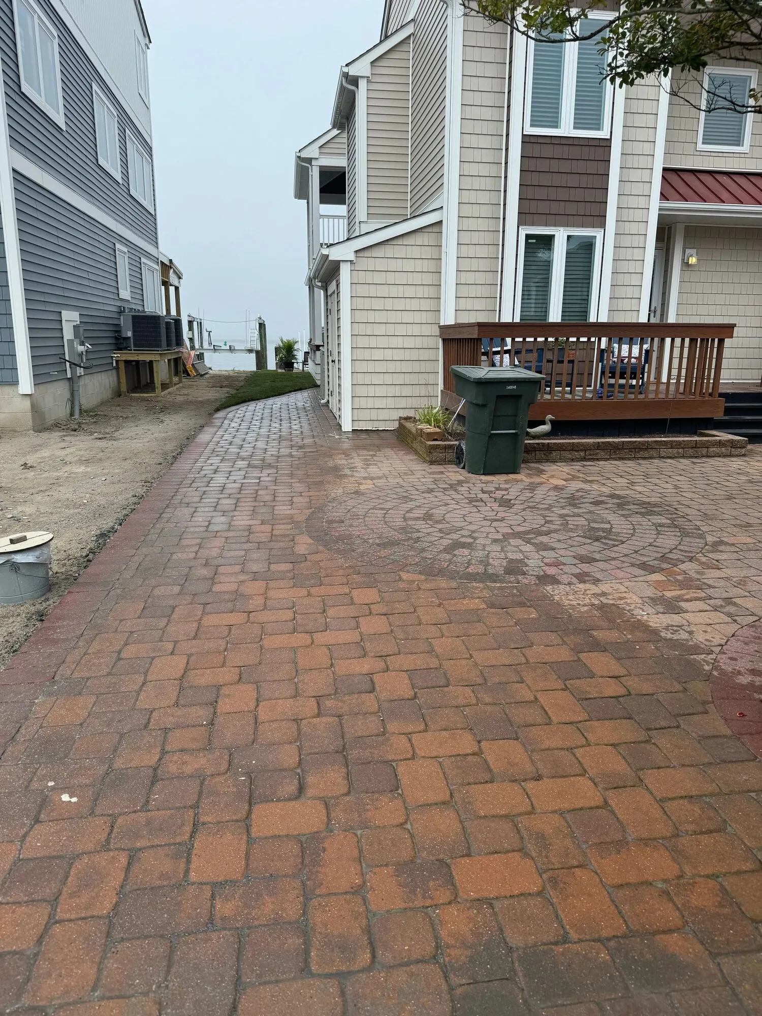 Red brick paver walkway leading to a coastal home